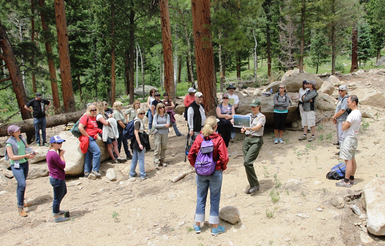 Over a dozen adult educators learning from a park ranger in Rocky Mountain National Park